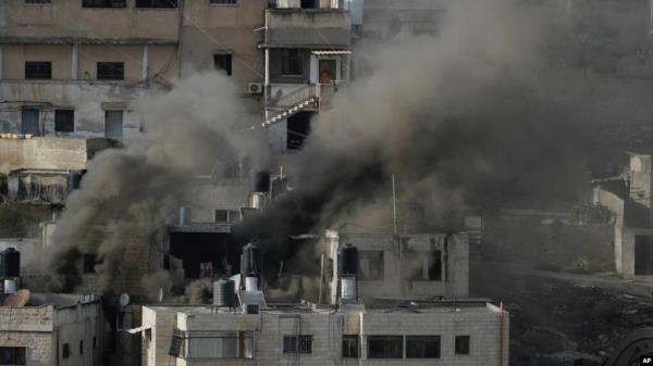 FILE - Houses are engulfed in fire as the Israeli army raided the northern West Bank town of Qabatiya, Sept. 19, 2024. An airstrike early Friday morning in Gaza City hit a family home, killing six people including an unknown number of children.